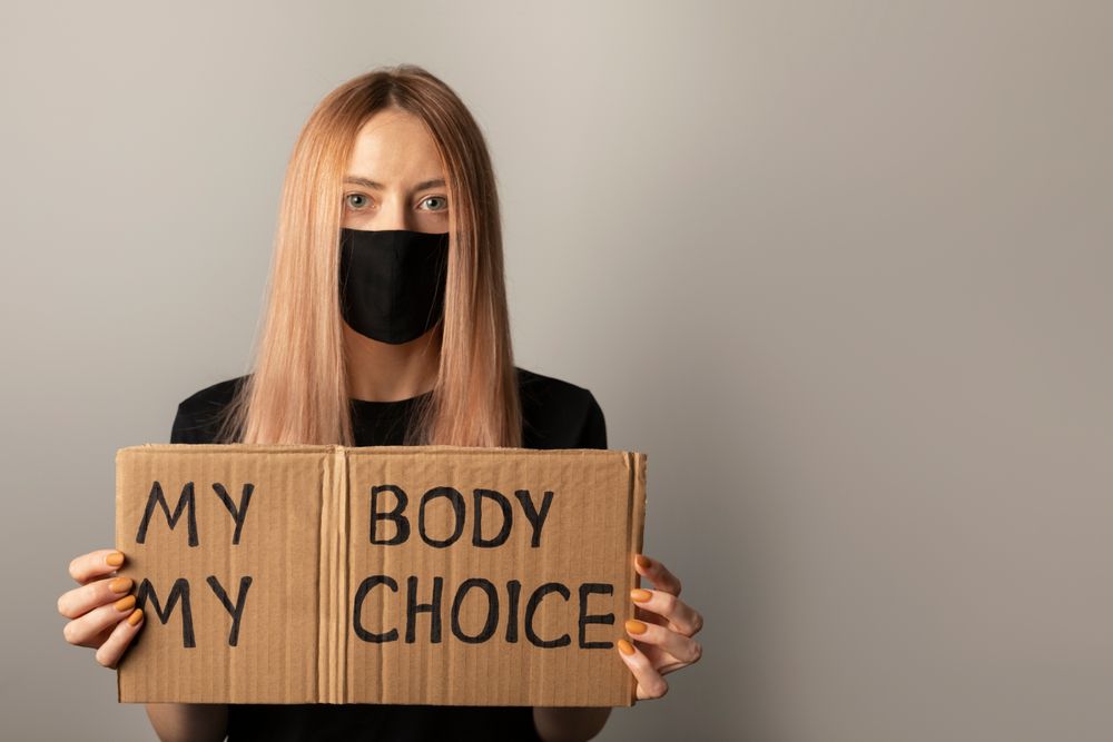 a woman holding a sign reading "My body my choice"